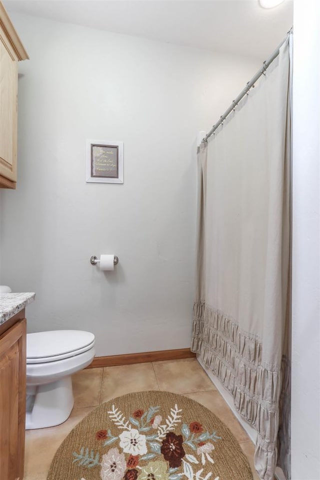 bathroom featuring vanity, tile patterned flooring, toilet, and baseboards