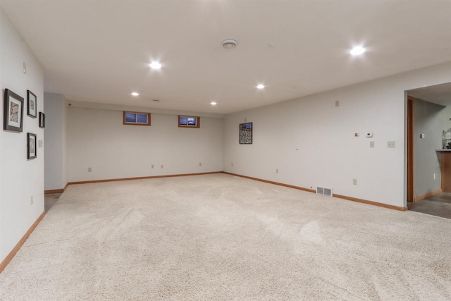 empty room featuring light colored carpet, recessed lighting, visible vents, and baseboards