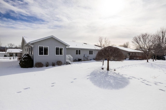 view of snow covered rear of property