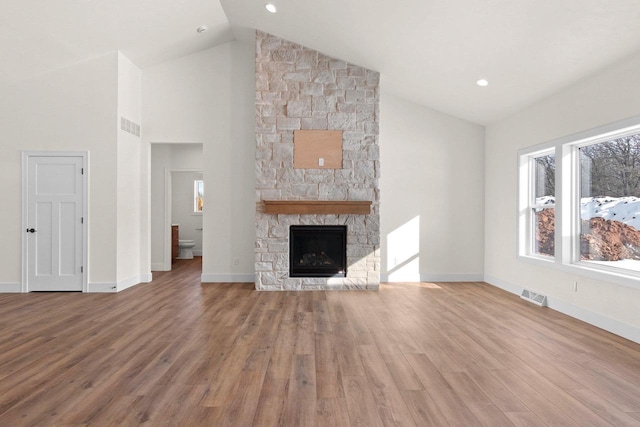 unfurnished living room with light wood-style flooring, a fireplace, visible vents, and baseboards