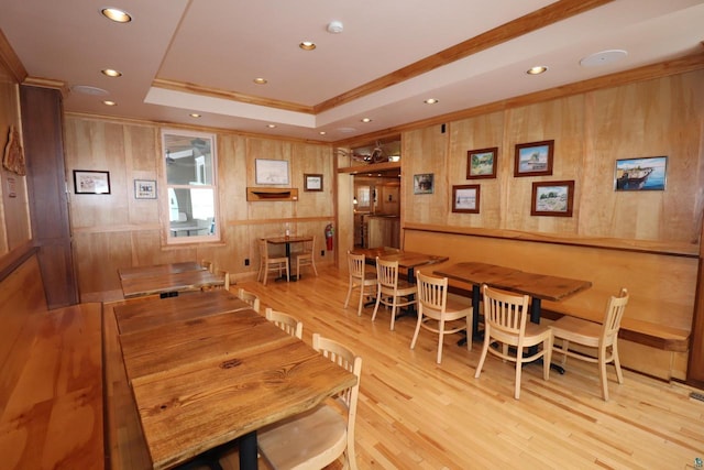 dining space with light wood-style flooring, a tray ceiling, crown molding, and recessed lighting