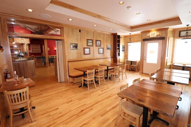 dining room with crown molding, recessed lighting, a raised ceiling, and light wood-style floors