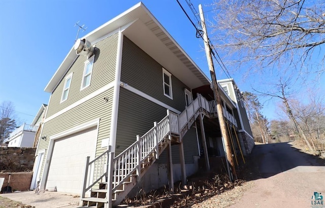 view of property exterior featuring a garage and stairs