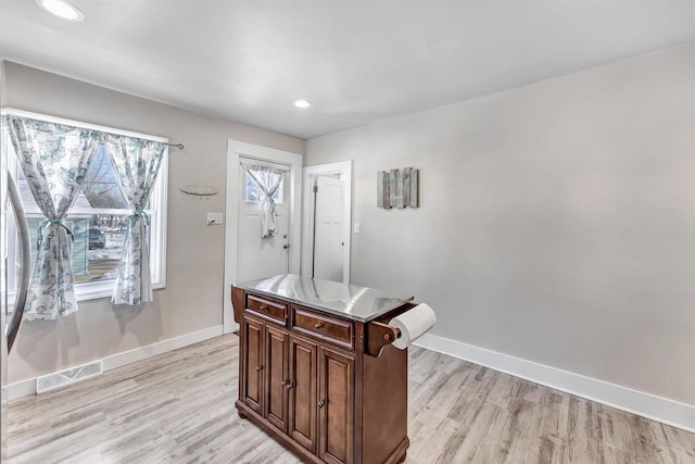 interior space with light wood finished floors, visible vents, and baseboards