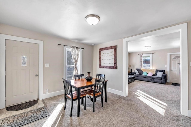 dining area with light carpet and baseboards