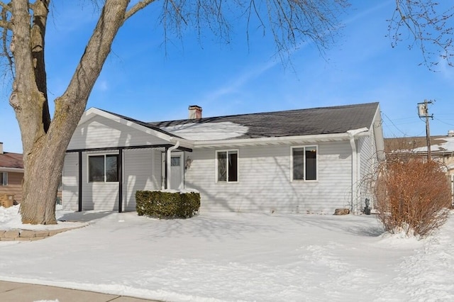 snow covered property with a chimney