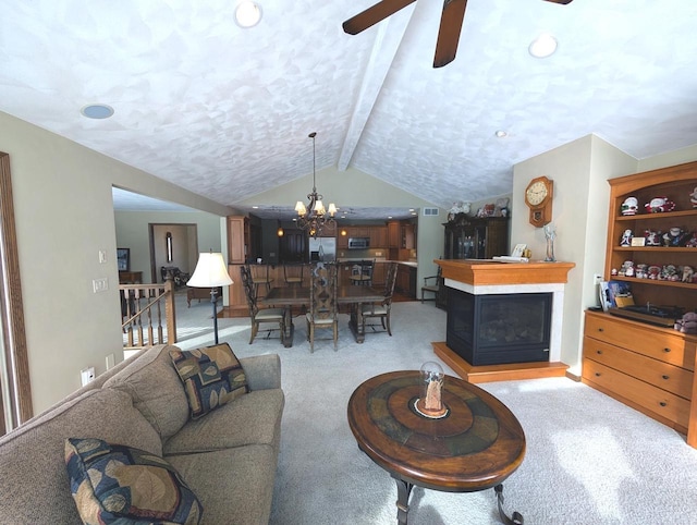 living room featuring a textured ceiling, light colored carpet, ceiling fan with notable chandelier, a fireplace, and vaulted ceiling