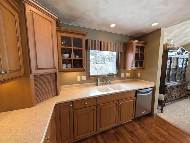 kitchen with light countertops, stainless steel dishwasher, a sink, and glass insert cabinets