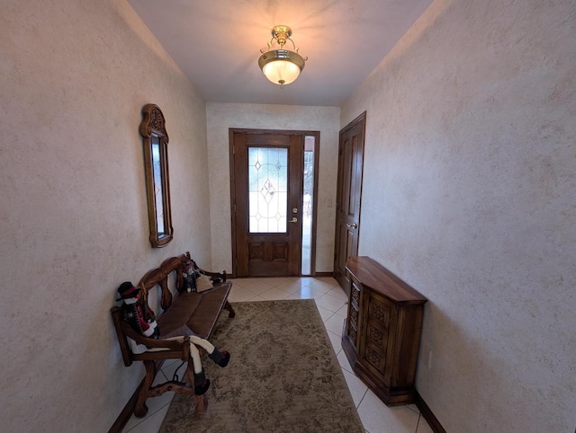 entryway with a textured wall and light tile patterned flooring