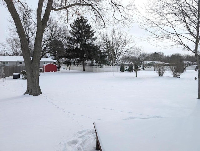 yard covered in snow with a garage and fence