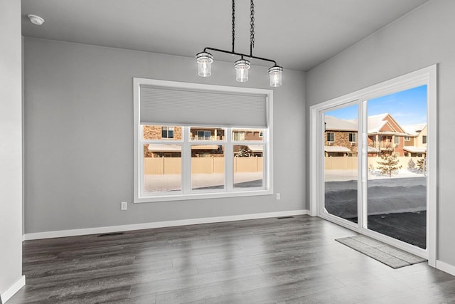 unfurnished dining area with visible vents, baseboards, and dark wood finished floors