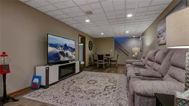 living area with a paneled ceiling, baseboards, wood finished floors, and recessed lighting