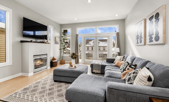 living area featuring recessed lighting, a fireplace, baseboards, and wood finished floors