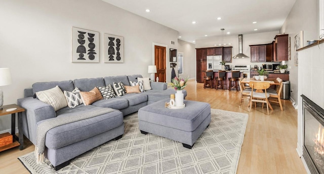 living room with light wood finished floors, visible vents, and recessed lighting