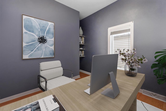 office area with visible vents, baseboards, and wood finished floors