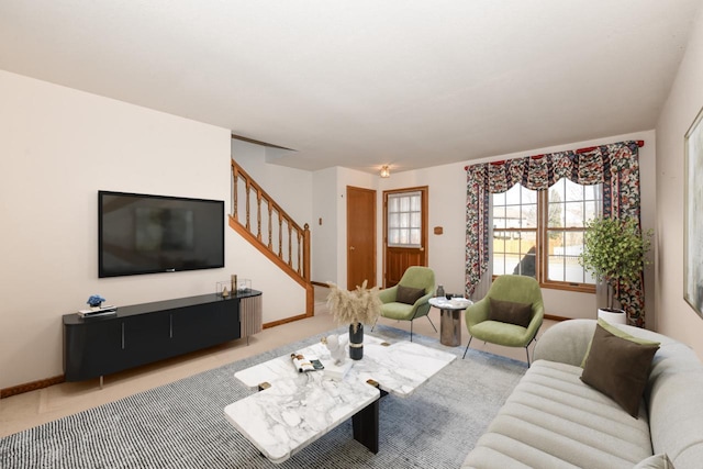 carpeted living area with stairs and baseboards