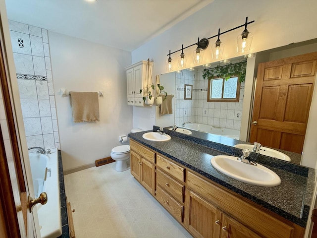 bathroom featuring a garden tub, baseboards, and a sink