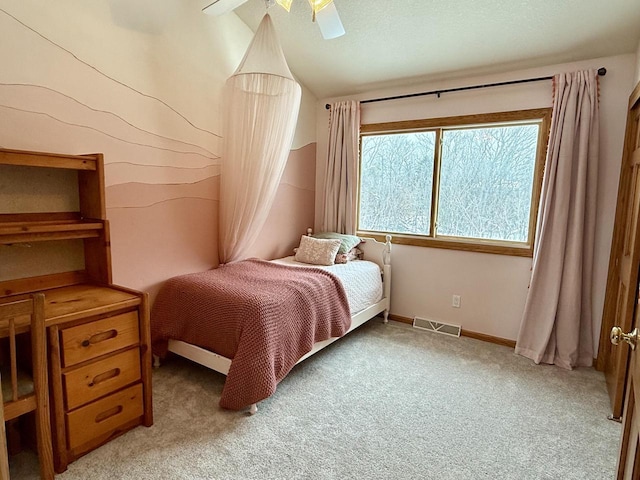 bedroom with lofted ceiling, light carpet, visible vents, baseboards, and a ceiling fan