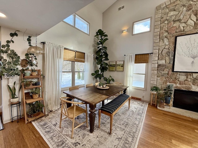 dining room with a wealth of natural light, light wood-type flooring, and a fireplace