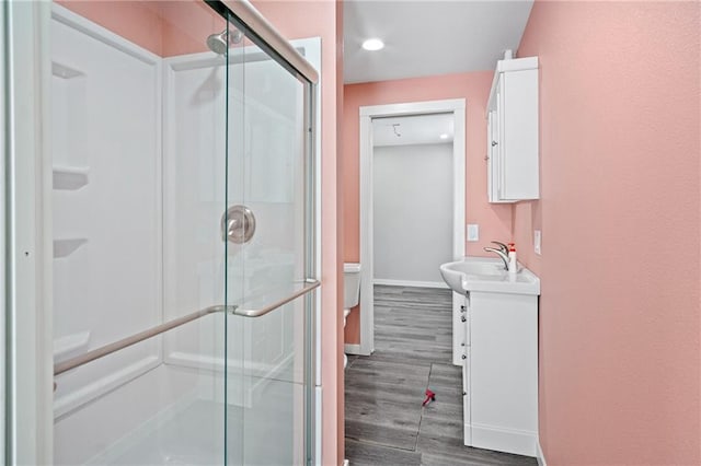 full bathroom featuring toilet, a shower stall, vanity, and wood finished floors