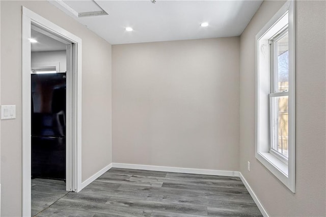 unfurnished room with recessed lighting, wood finished floors, and baseboards