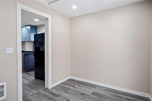 empty room featuring dark wood-style floors, recessed lighting, visible vents, and baseboards