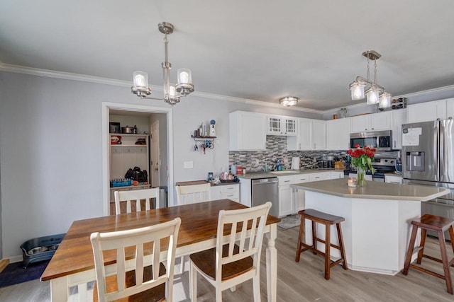 kitchen featuring pendant lighting, light countertops, appliances with stainless steel finishes, and white cabinets