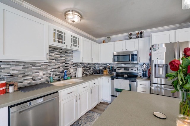 kitchen with stainless steel appliances, glass insert cabinets, and white cabinetry