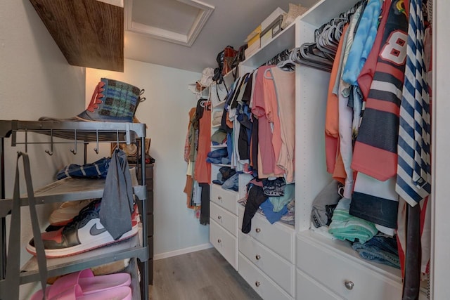 spacious closet with light wood-style floors and attic access