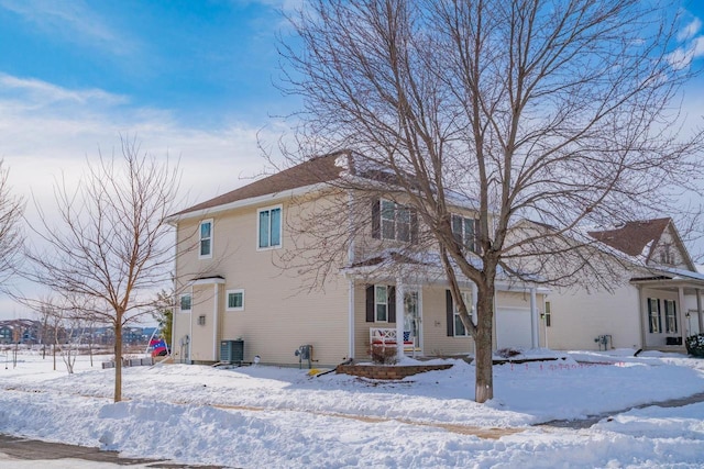 view of front of property featuring an attached garage and central AC