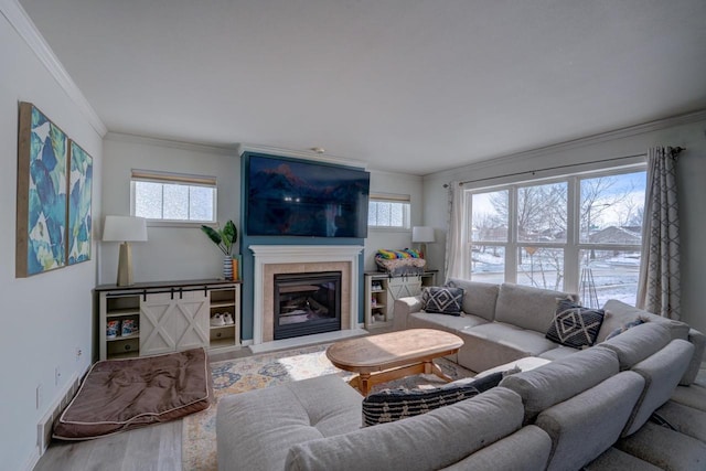 living room with a fireplace, crown molding, baseboards, and wood finished floors