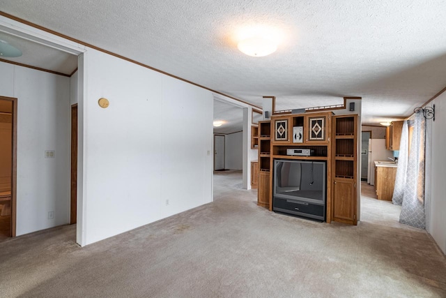 unfurnished living room featuring ornamental molding, light carpet, and a textured ceiling