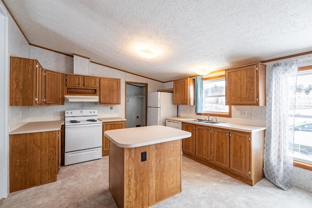 kitchen with lofted ceiling, white appliances, a kitchen island, light countertops, and brown cabinetry