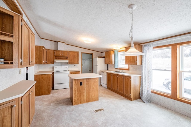 kitchen featuring white appliances, a kitchen island, hanging light fixtures, light countertops, and a sink