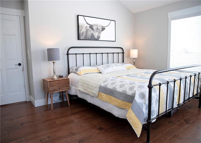 bedroom featuring vaulted ceiling, dark wood finished floors, and baseboards