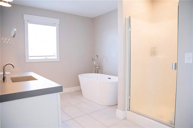 bathroom featuring vanity, baseboards, a soaking tub, tile patterned floors, and a stall shower