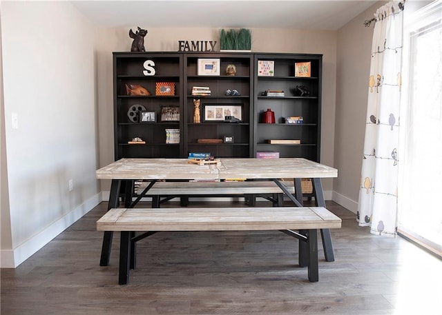 dining space featuring baseboards and wood finished floors