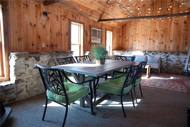 dining room featuring lofted ceiling, wood ceiling, and wooden walls