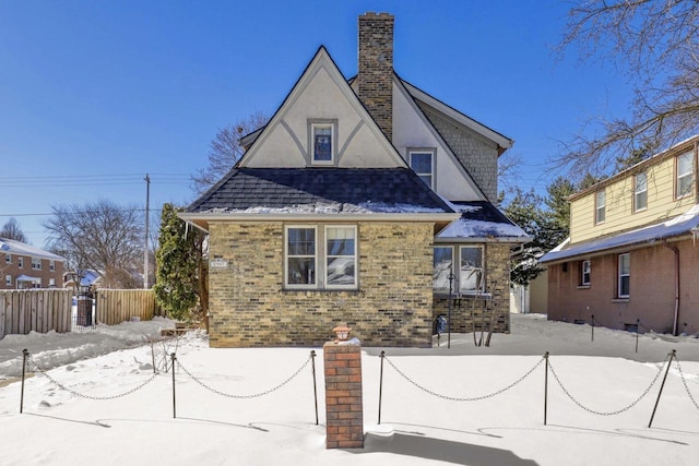 exterior space featuring roof with shingles, brick siding, fence, and stucco siding