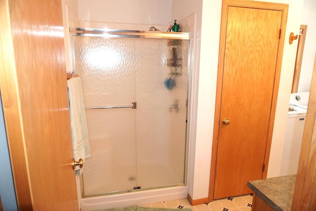 bathroom with washer / clothes dryer, a shower stall, and vanity