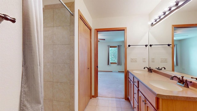 full bath with double vanity, a tile shower, a sink, and tile patterned floors