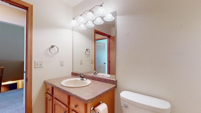 bathroom with toilet, tile patterned floors, and vanity