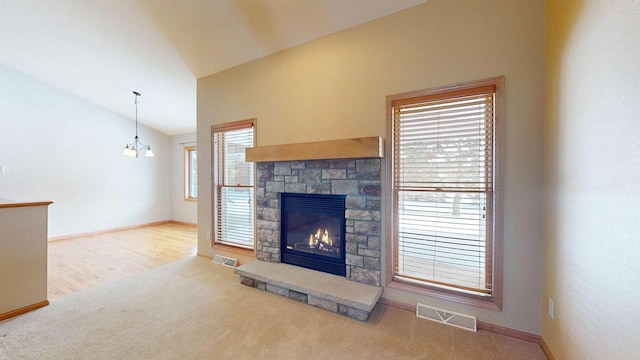 unfurnished living room featuring vaulted ceiling, carpet floors, a fireplace, and visible vents