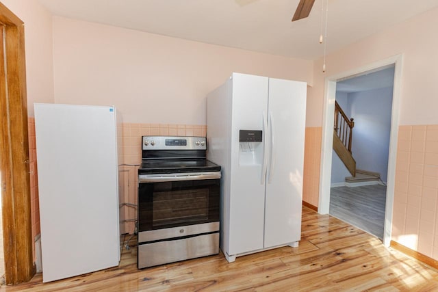 kitchen with electric range, ceiling fan, light wood-style flooring, freestanding refrigerator, and white fridge with ice dispenser