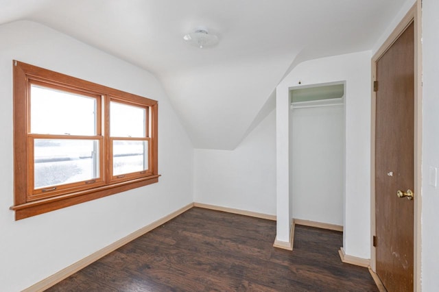 additional living space featuring vaulted ceiling, dark wood finished floors, and baseboards