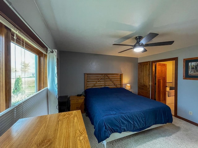 bedroom featuring a ceiling fan, carpet flooring, baseboards, and ensuite bathroom