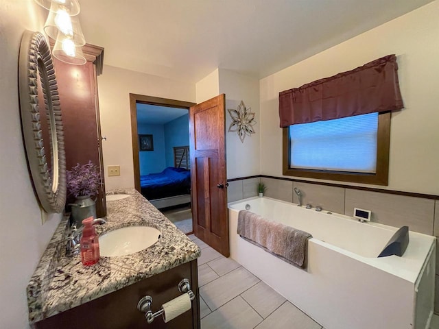 bathroom featuring double vanity, connected bathroom, a garden tub, tile patterned flooring, and a sink