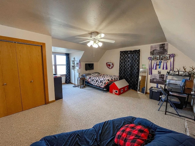 bedroom with a ceiling fan, lofted ceiling, carpet flooring, and a textured ceiling