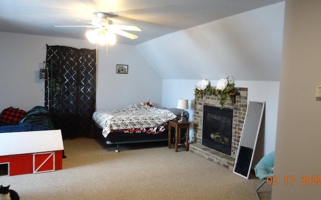 bedroom with a ceiling fan, a brick fireplace, carpet flooring, and vaulted ceiling