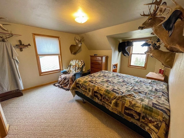 carpeted bedroom with lofted ceiling, a textured ceiling, and baseboards